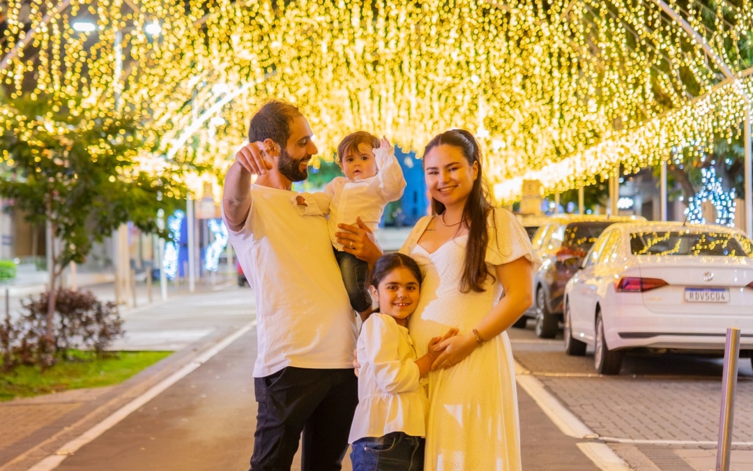 Jovens apaixonados ficam sabendo que estão esperando um menino em Chá Revelação sob as luzes douradas, receptivas e alegres do Túnel Encantado