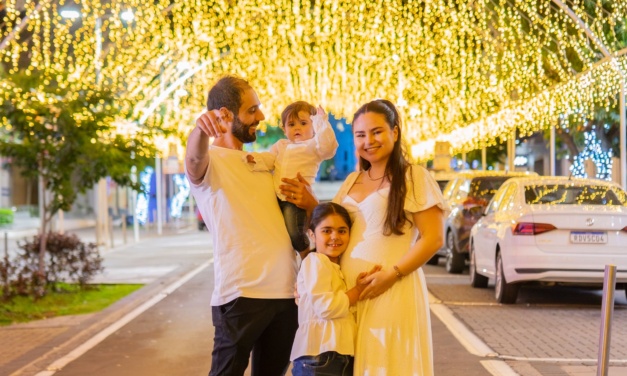 Jovens apaixonados ficam sabendo que estão esperando um menino em Chá Revelação sob as luzes douradas, receptivas e alegres do Túnel Encantado
